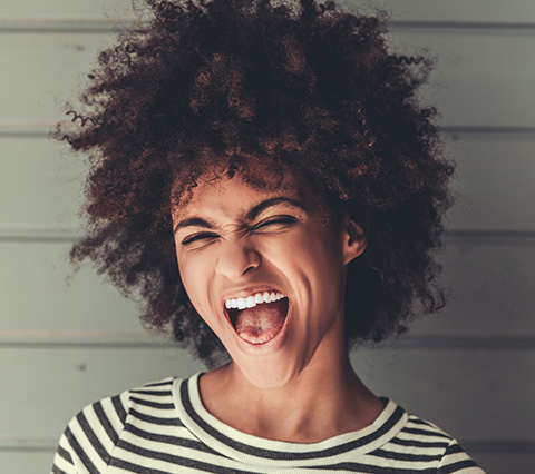 Con ortodoncia sin brackets Bogotá siempre serás feliz Mujer mostrando su sonrisa porque tiene ortodoncia sin brackets Bogotá